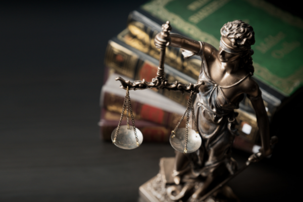 Legislation books with statue of justice scales