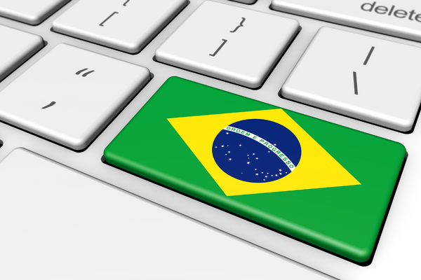 A close up of a white computer keyboard with the flag for Brazil superimposed on top of the Enter/Return key