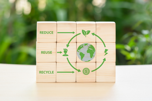 A photo of small, wooden building blocks that are put together and form a picture of an earth with the words "reduce, reuse, recycle"